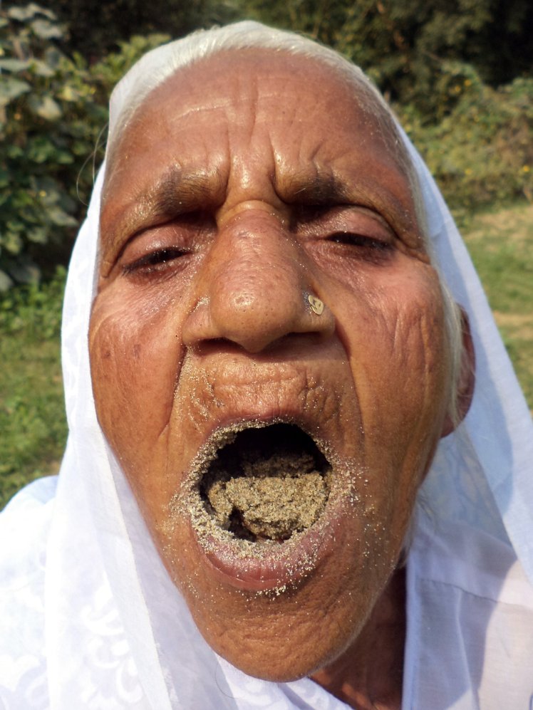 PIC FROM Caters News - (PICTURED: Kusma Vati, 78 eating sand) - An elderly woman from Varanasi, India, has eaten sand and gravel for the last six decades and claims the unique diet has been key to her good health. Kusma Vati, 78, is so addicted to eating sand and gravel that she spends hours in search of her staple diet and if she has no luck, she will even nibble on the walls of her own house. Her bizarre taste for stone has stunned everyone in her area of the city yet the granny claims it is because of sand and gravel that she has never felt sick. SEE CATERS COPY.